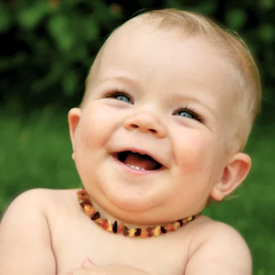 comprendre les bienfaits de l'ambre. Bébé heureux avec un collier d'ambre.