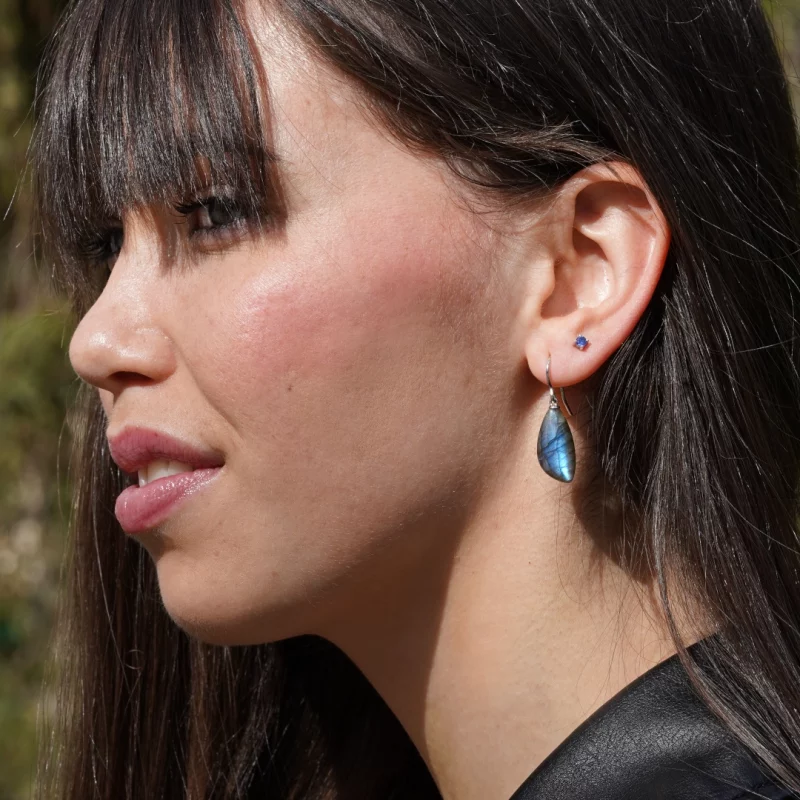 pierres tendances : la labradorite. Image d'illustration avec une modèle portant des boucles d'oreilles pendantes en labradorite