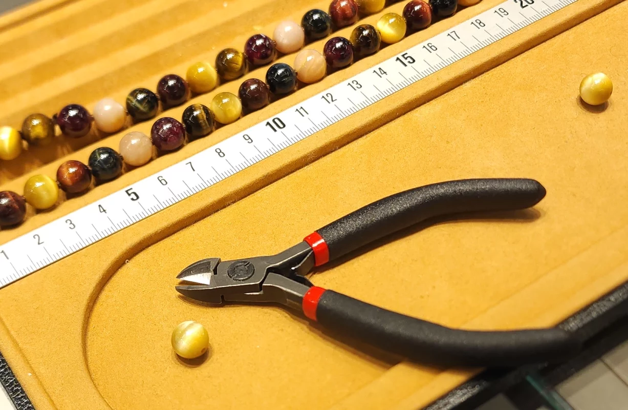 slider réparations et créations : photo d'une planche de création de bijoux avec des billes de pierres