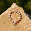 bracelet en agate fleur de cerisier et charm en acier doré. photo avec décors