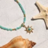collier en amazonite avec pendentif en forme de soleil. photo plan rapproché avec décors