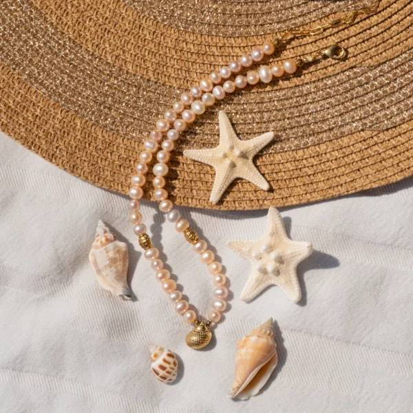collier en perles blanches avec charm coquillage photo avec décors