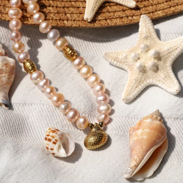 collier en perles blanches avec charm coquillage photo avec décors