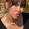 collier en perle avec charm doré porté par une modèle