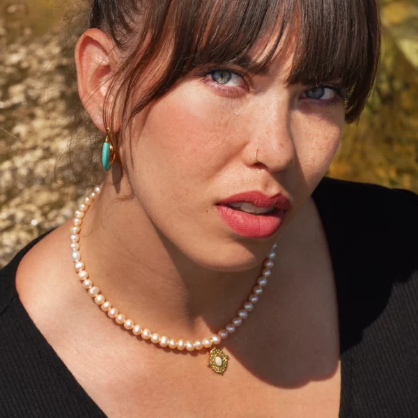 collier en perle avec charm doré porté par une modèle