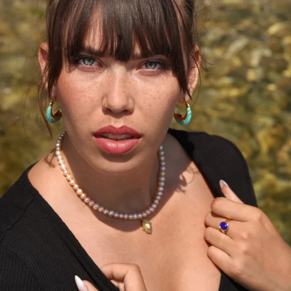 collier en perle avec charm doré porté par une modèle