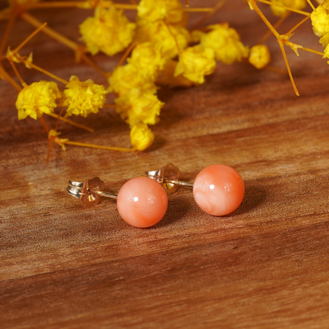 clous d'oreilles en corail rose et or, photo avec décors