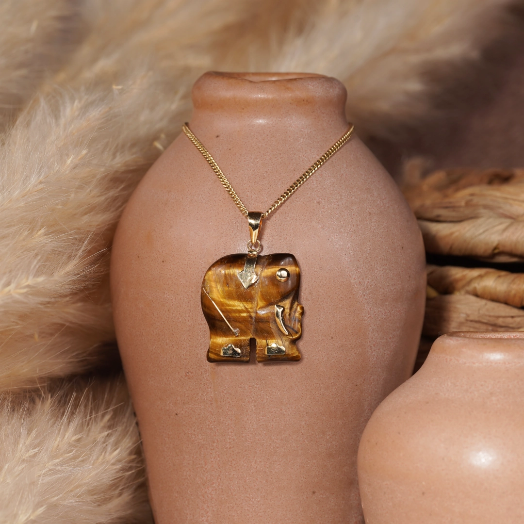 pendentif éléphant en oeil de tigre et or, photo avec décors