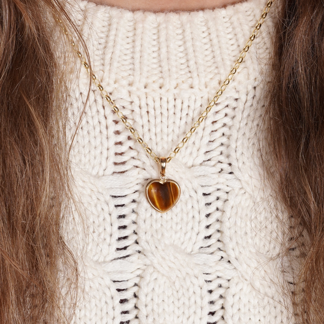 pendentif en forme de coeur en or et oeil de tigre. photo porté par modèle