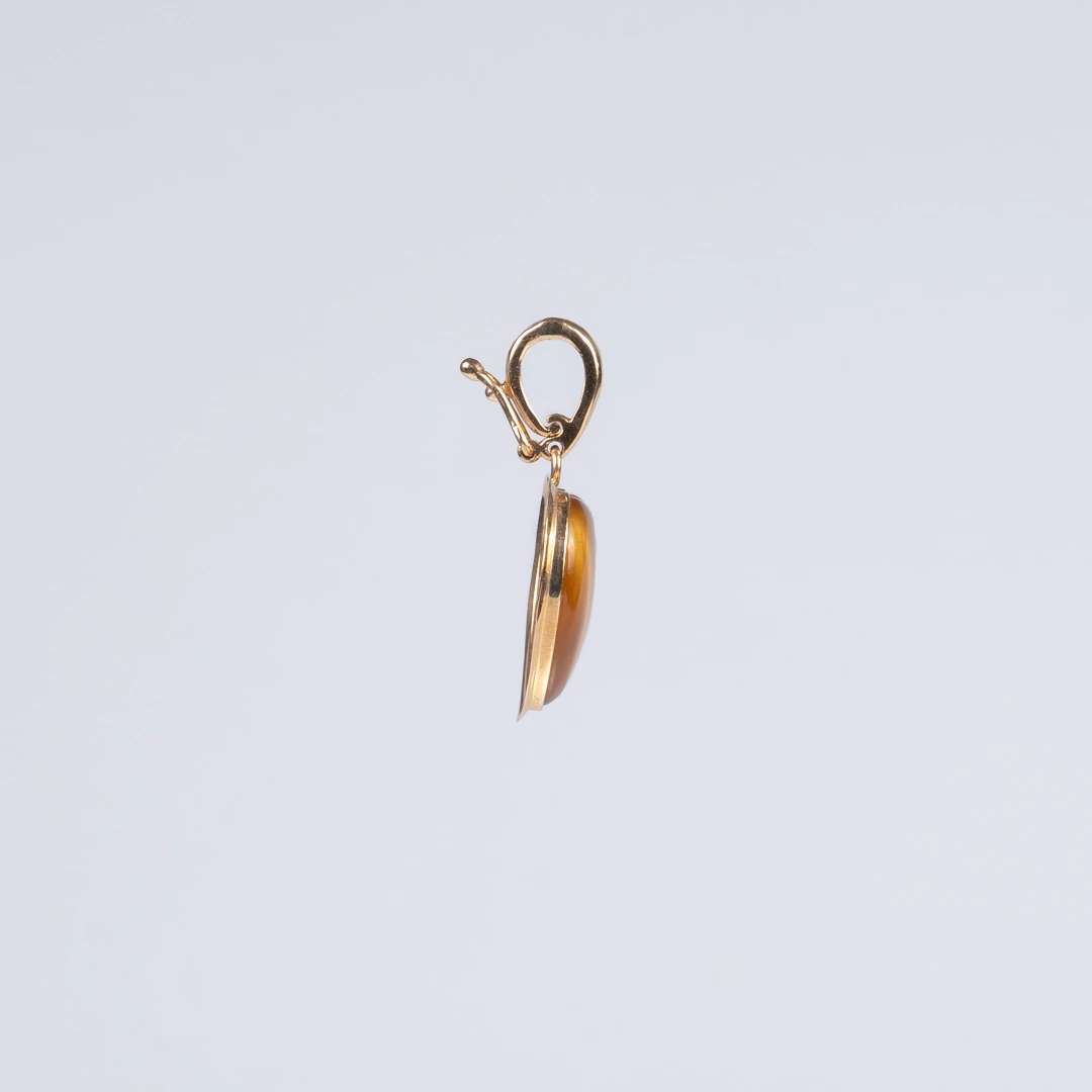 pendentif en forme de coeur en or et oeil de tigre. photo sur fond blanc de côté