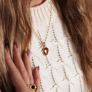 pendentif en forme de coeur en or et oeil de tigre. photo porté par modèle