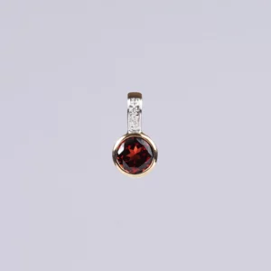 pendentif rond en grenat, diamants et or, photo sur fond blanc