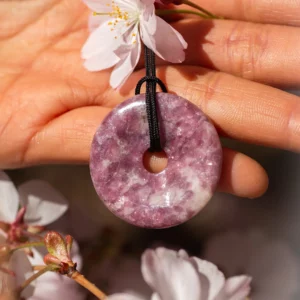 pendentif donut pi en lépidolite, photo tenu par une main