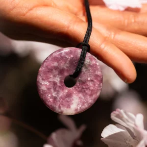 pendentif donut pi en lépidolite, photo tenu par une main
