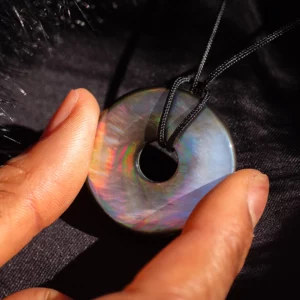 pendentif donut pi en nacre, photo tenu par une main