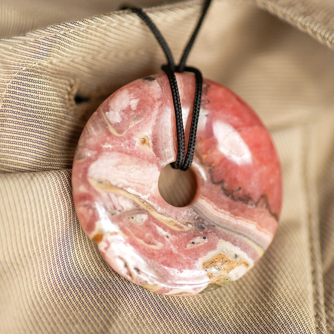 pendentif donut pi en rhodochrosite, photo avec décors